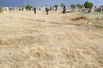  Дворники группы хозяйственного обслуживания и благоустройства администрации ГГМО РК ведут покос травы на городском кладбище.